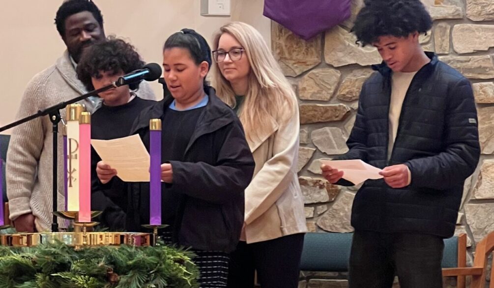 Family lighting the Advent candle representing hope