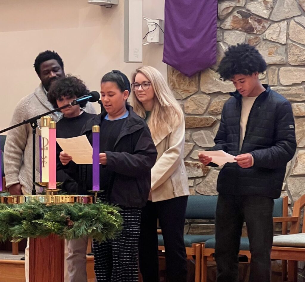 Family lighting the Advent candle representing hope