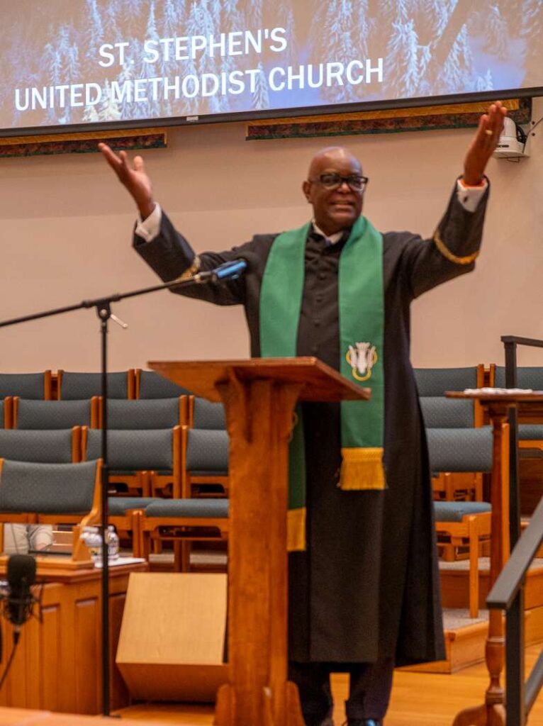 Pastor Chaney with his arms raised.