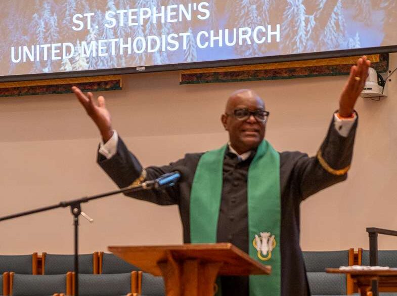 Pastor Chaney with his arms raised.