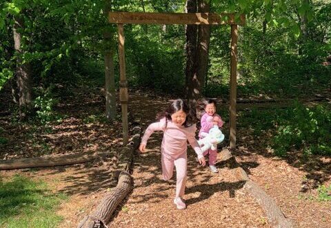 Two girls running out of urban forest