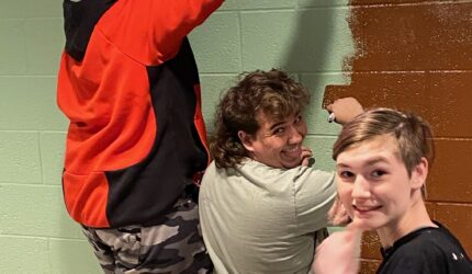 Youth group members painting a mural