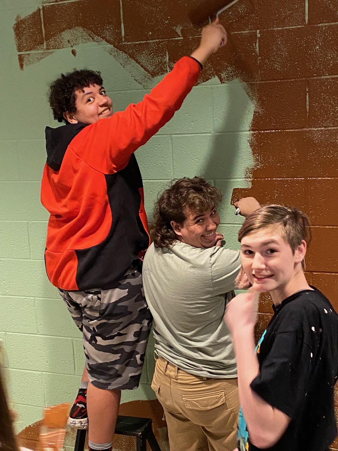 Youth group members painting a mural